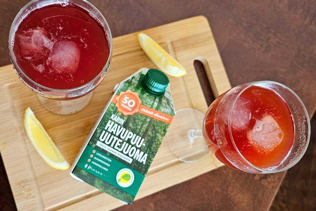 Karin Havupuu-uutejuomasta tehdyt alkoholittomat drinkit, mukana sitruunaa ja omenamehua. drinkit ja tölkki leikkuulaudan päällä sekä sitruunanpuolikkaat.