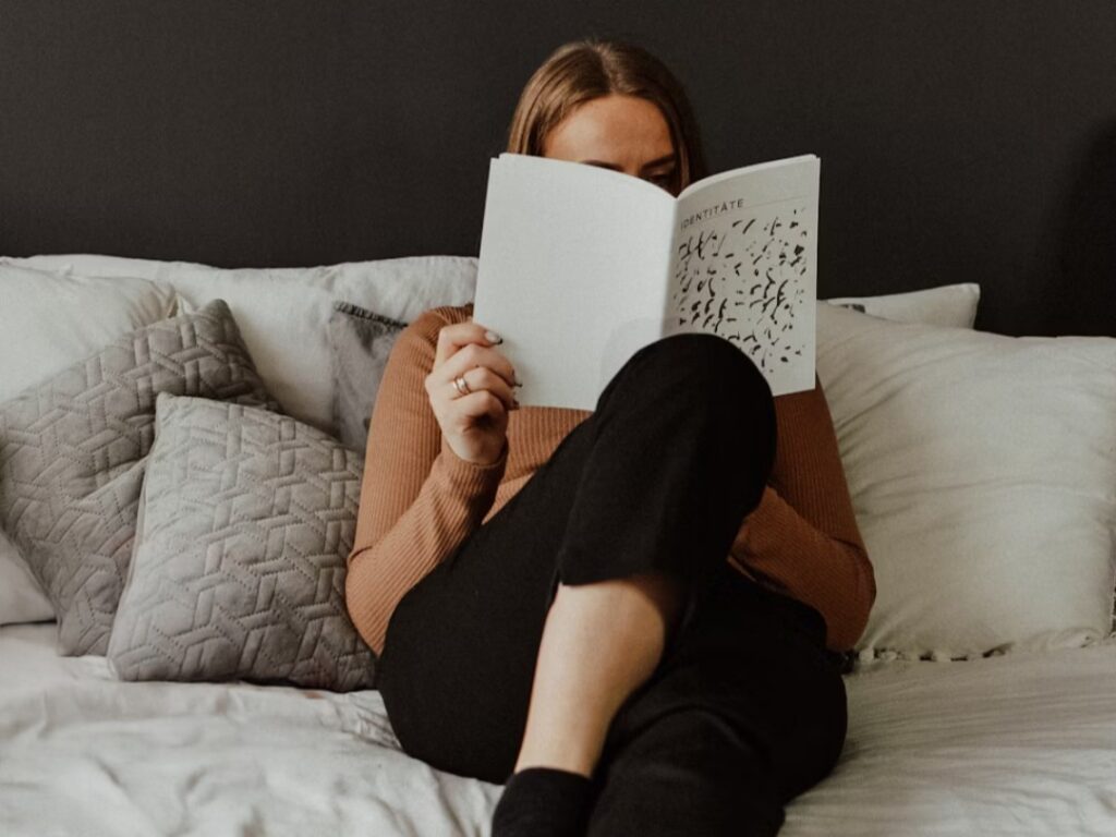 nainen lukee kirjaa sängyssä